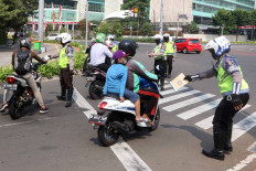 Jakarta Police traffic officers stop motorcyclists during Operation Patuh Jaya 2020 – an effort to enforce PSBB restrictions and traffic laws in the city – on Jl. Imam Bonjol in Central Jakarta on Aug. 3. The Jakarta Police ticketed about 23,000 drivers in the first 10 days of the operation. JP/Dhoni Setiawan