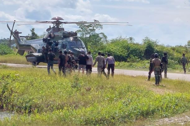 Rescue mission: Military and police personnel surround a helicopter on Feb. 2, 2023, in Kenyam district in the Papua regency of Nduga. The chopper was used to evacuate 15 people who had allegedly been held hostage by a separatist armed group.