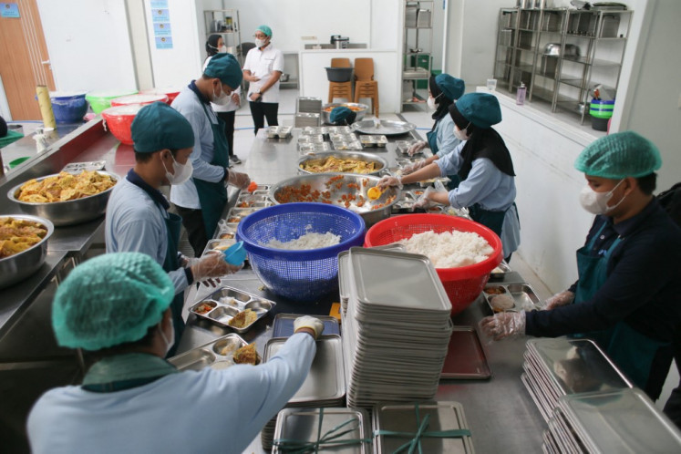 Staff prepare lunch plates on the first day of the free nutritious meal program at a kitchen in Bogor, West Java, on Jan. 6, 2025. 