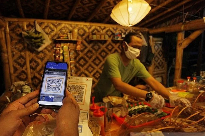 A buyer pays his bill using Quick Response Indonesia Standard (QRIS) code at a street foodstall on Jl. Ampera Raya in South Jakarta on Feb. 6, 2021. 